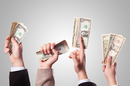 hands waving dollar bills in the air