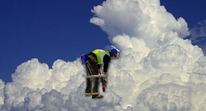 workman in high vis jacket bent over, super-imposed on cloud background