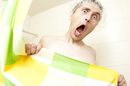 Man in shower photo via Shutterstock
