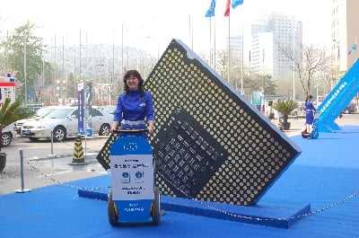 Shot of women on a Segway by a large replica of an Intel chip