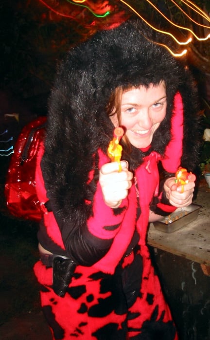 Female 'headless' furry in red costume - indeterminate animal - semi-crouching, smiling with water-pistol in hand