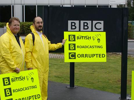 Free software protestors hold up their sign against the BBC's White City sign