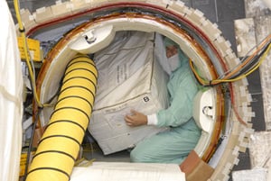 Technician loading ISS toilet spares onto Discovery