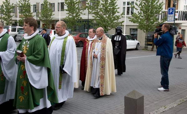 Photo in Bondi showing Darth Vader following procession of Anglican clergy