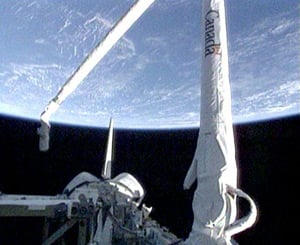 Discovery's robotic arm deployed. Pic NASA