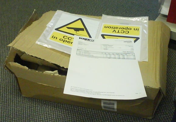 Two CCTV warning signs in an excessively large box