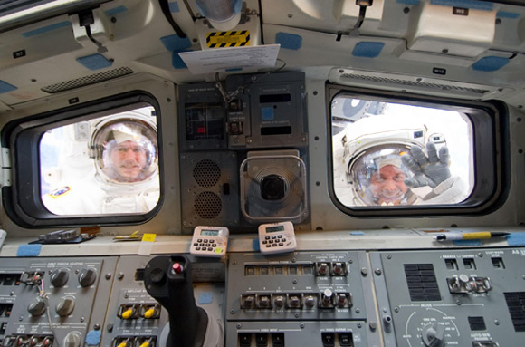 Michael Good (left) and Garrett Reisman caught through the windows of Atlantis. Pic: NASA