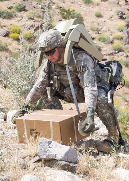 A soldier wearing a HULC exoskeleton lifts something heavy. Credit: Lockheed