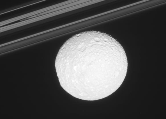 'The bright, icy moon [Mimas] in front of Saturn's delicate rings'. Image credit: NASA/JPL/SSI