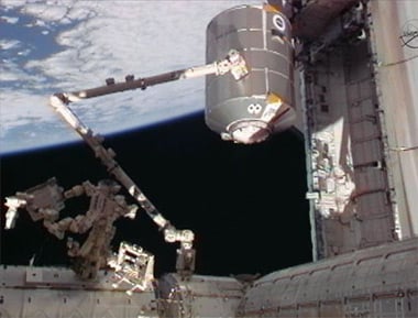 The station's robotic arm, Canadarm2, operated by STS-135 astronauts Doug Hurley and Sandy Magnus, grapples the Raffaello multipurpose logistics module from the shuttle's payload bay. Pic: NASA TV 
