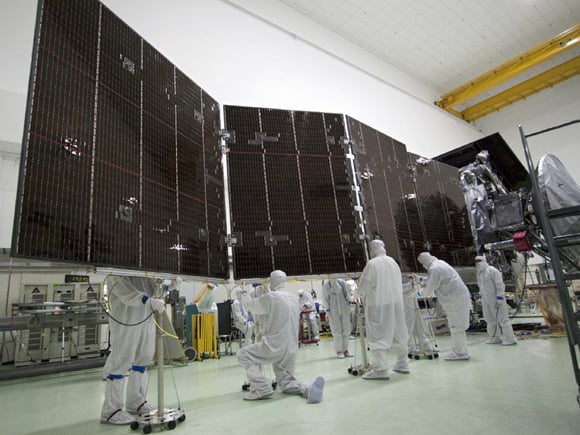 Technicians at Astrotech's payload processing facility in Titusville, Florida, stow solar array number 2 against the body of NASA's Juno spacecraft, NASA explains