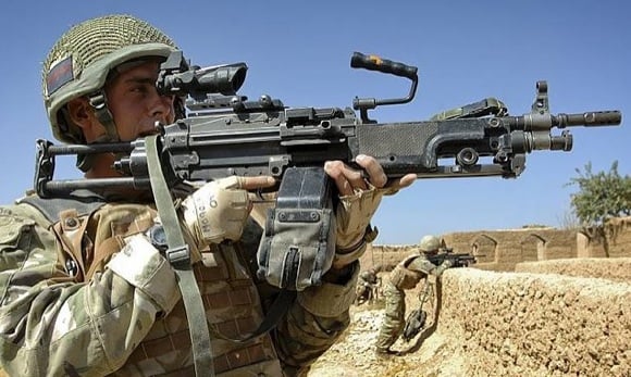 A soldier from the Scots Guards pictured with a Light Machine Gun (LMG) near the village of Inzgule, Helmand, Afghanistan. Credit: Cpl Mark Webster/Crown Copyright