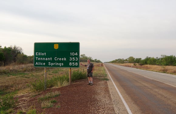 Lester Haines besides a roadsign on the Stuart Highway