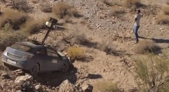 A still showing the crashed Street View car in a rocky gorge