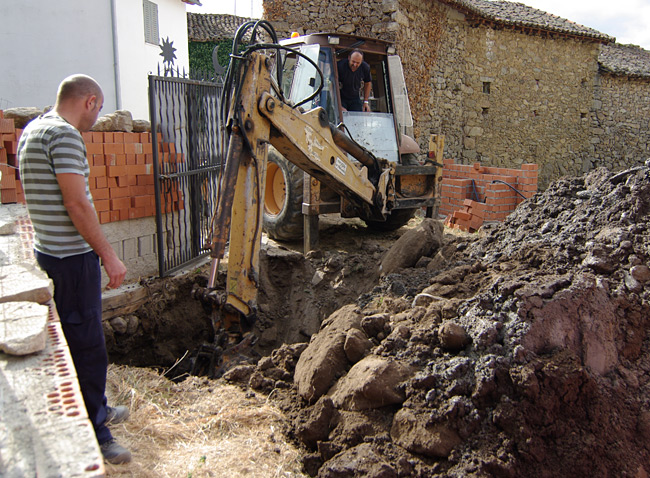 Rui contemplates a big hole next to an enormous pile of earth, as Ramon continues to dig