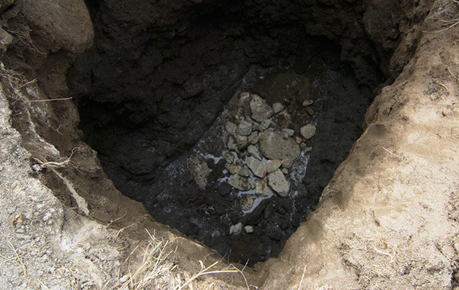 The really big hole for the well, with some stone at the bottom