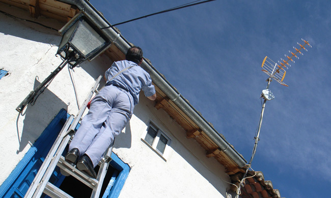 Man up ladder installing the Iberbanda receiver