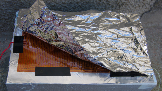 The heater on top of an aluminium sheet, with space blanket on top