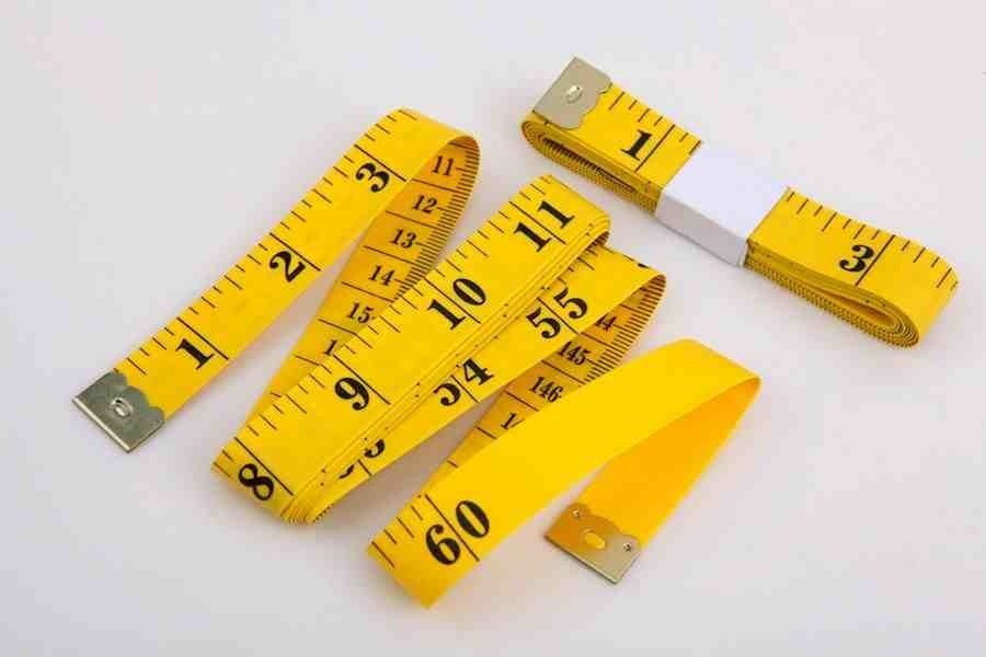 yellow measuring tape - black writing