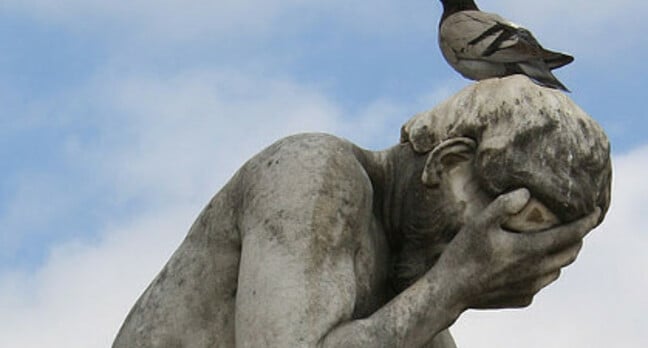 Pigeon crapping on statue