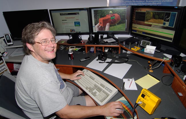 Dave Akerman sits at his mighty bank of monitors