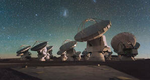 The Atacama Large Millimeter/submillimeter Array (ALMA) by night, under the Magellanic Clouds