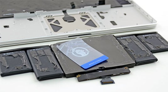 Photo of a MacBook Pro battery pried from its case