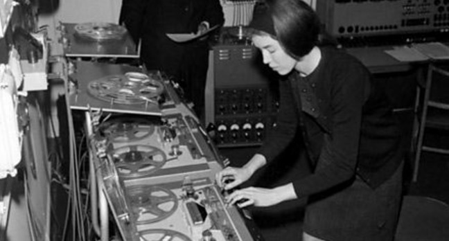 Delia Derbyshire edits on a Philips EL3503 while Desmond Briscoe checks the script