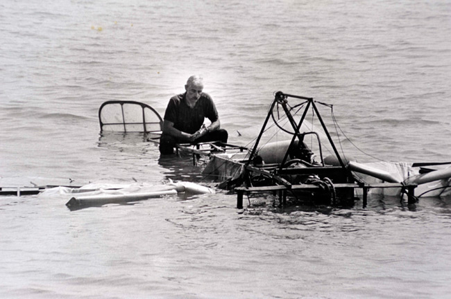 Pilot atop sinking vintage aircraft