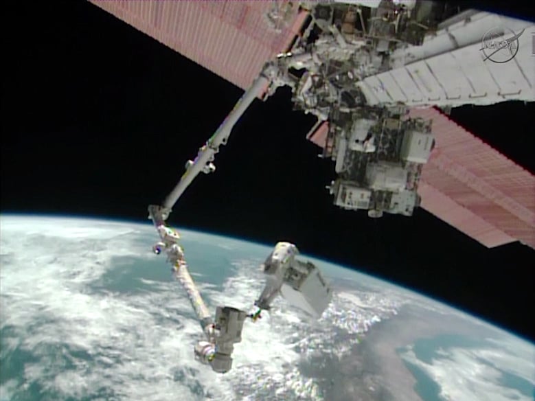 Astronaut Mike Hopkins rides the Canadarm2 carrying the 780-pound ammonia pump module as the International Space Station flies over South America