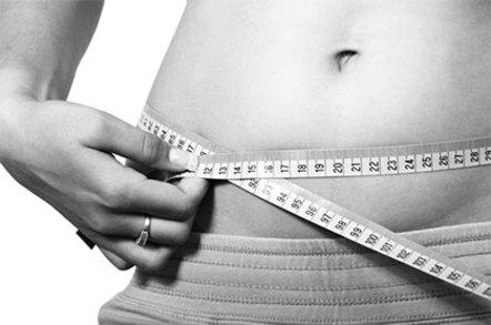 A person measuring her waistline