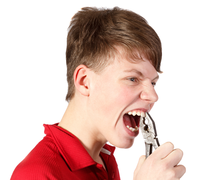 Youth gripping his front teeth with a pair of pliers