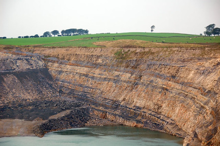 The northern end of the huge water-filled pit, showing the coal seams in the rock at Broken Cross Muir opencast coal mine