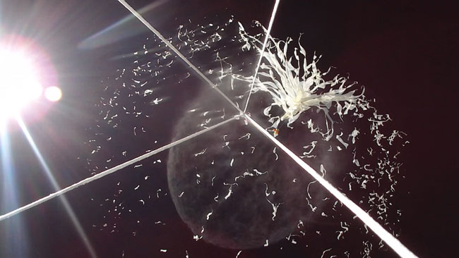 Pieces of shredded latex radiate out as the balloon bursts