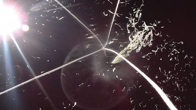 Shredded latex radiates out from the burst balloon