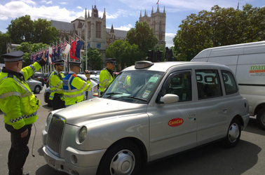Police direct a cabbie at the Uber protest in London
