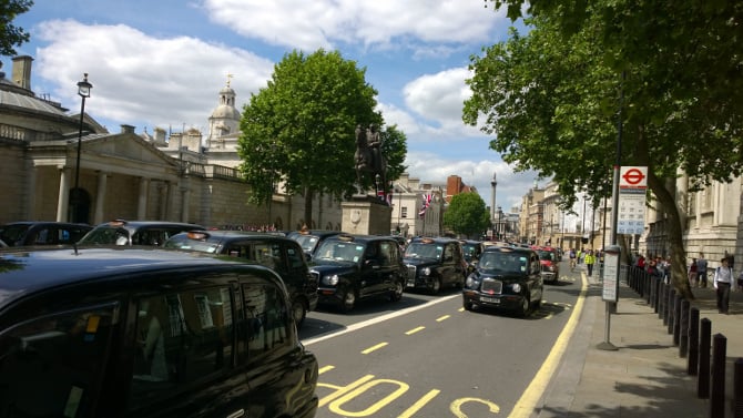 Black cabs crawl along Whitehall