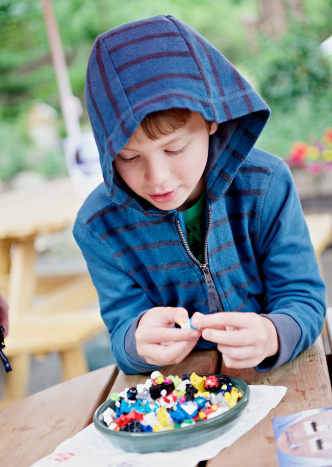  lad picks a Legonaut from a selection of miniature adventurers