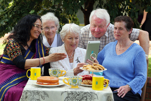 Racially diverse mix of old people looking at The Archers website