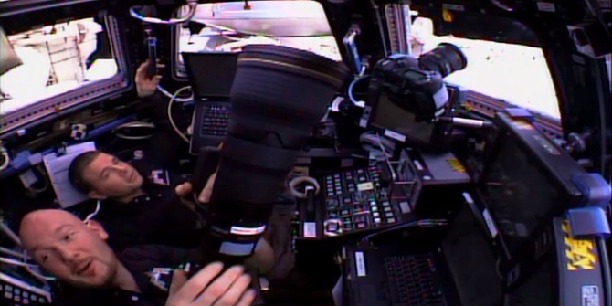 Alexander Gerst and Reid Wiseman watch the approach of the SpaceX Dragon from the Cupola.