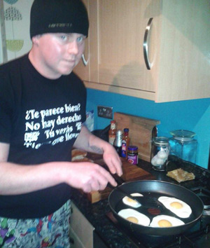 Sean frying four eggs for the chilli chutney egg sarnie