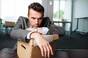 Sad man stares glumly over boxed contents of desk. Image via shutterstock (Baranq)