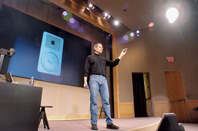 Steve Jobs presents the iPod to an audience of press and Apple employees