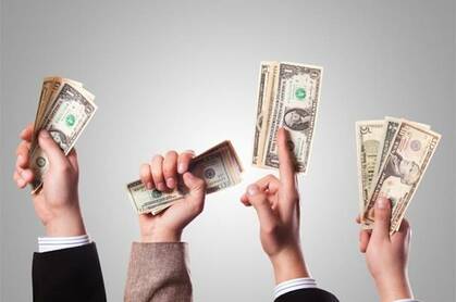 hands waving dollar bills in the air