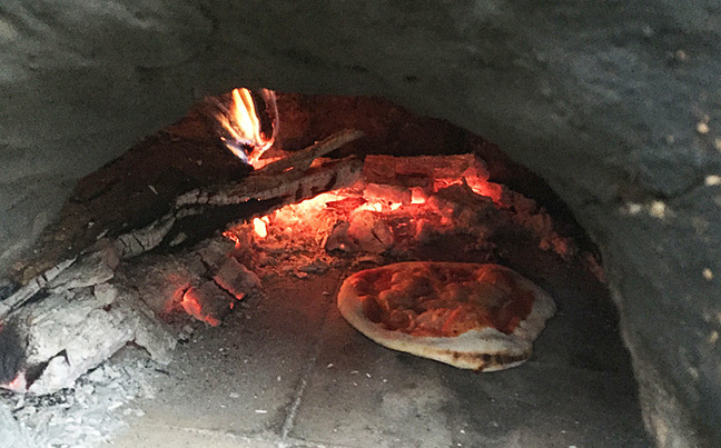 A pizza in a wood-fired oven