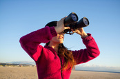 woman binoculars photo via Shutterstock