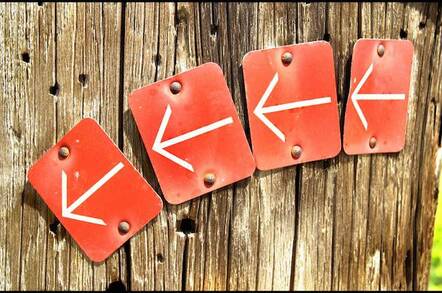 4 arrows signs in arrow on wooden wall