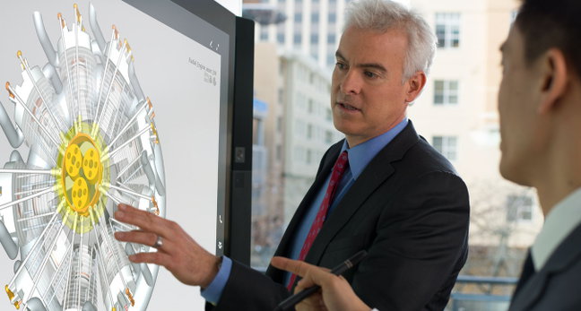 Two people manipulate a CAD design on a Microsoft Surface Hub