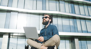 Hipster with laptop photo via Shutterstock