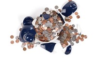 Broken piggy bank with coins surrounding it. Image via Shutterstock